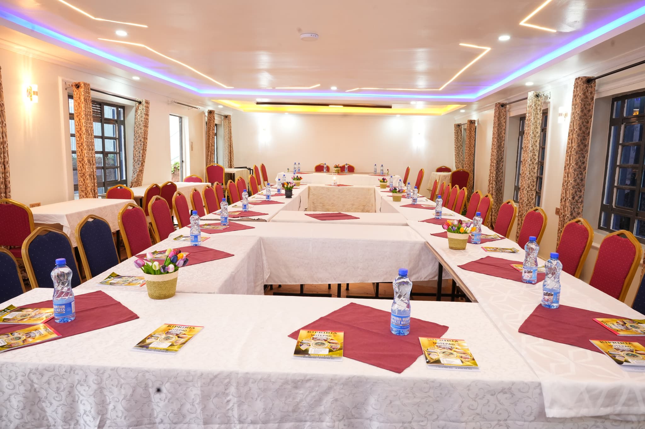 Modern conference room with timber table, cream chairs and wall-mounted screen overlooking highlands